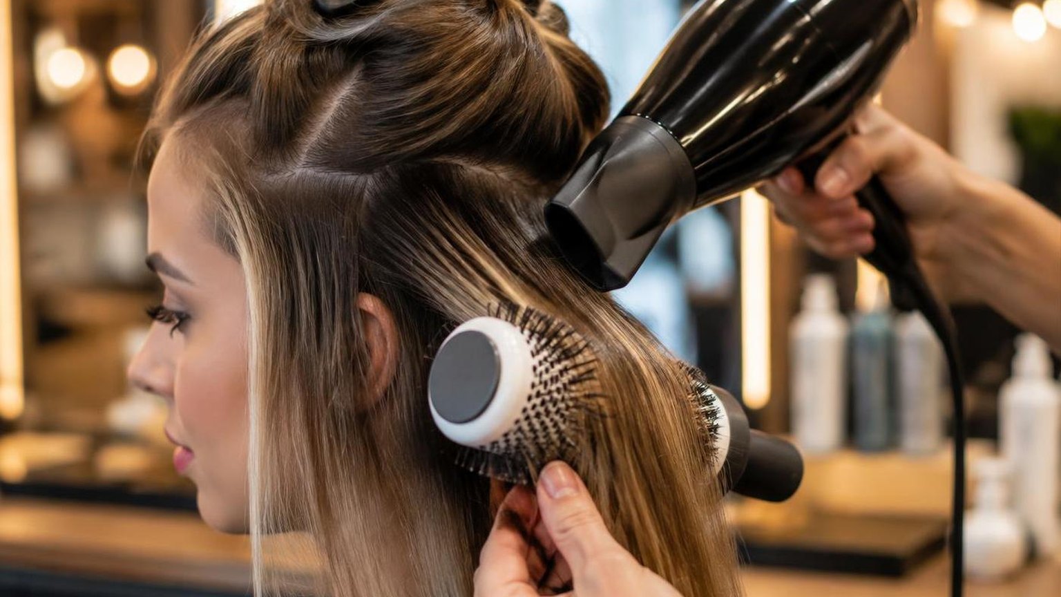 The workstation mid-service, tools in use and hair in motion, during a real blow dry
