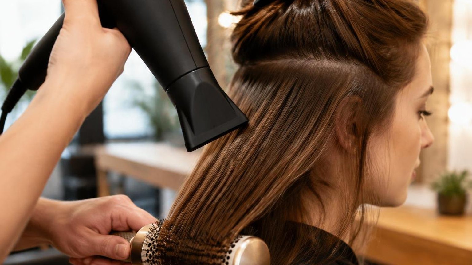 A stylist working through a sectioned blow dry, close-up, during a real blow dry