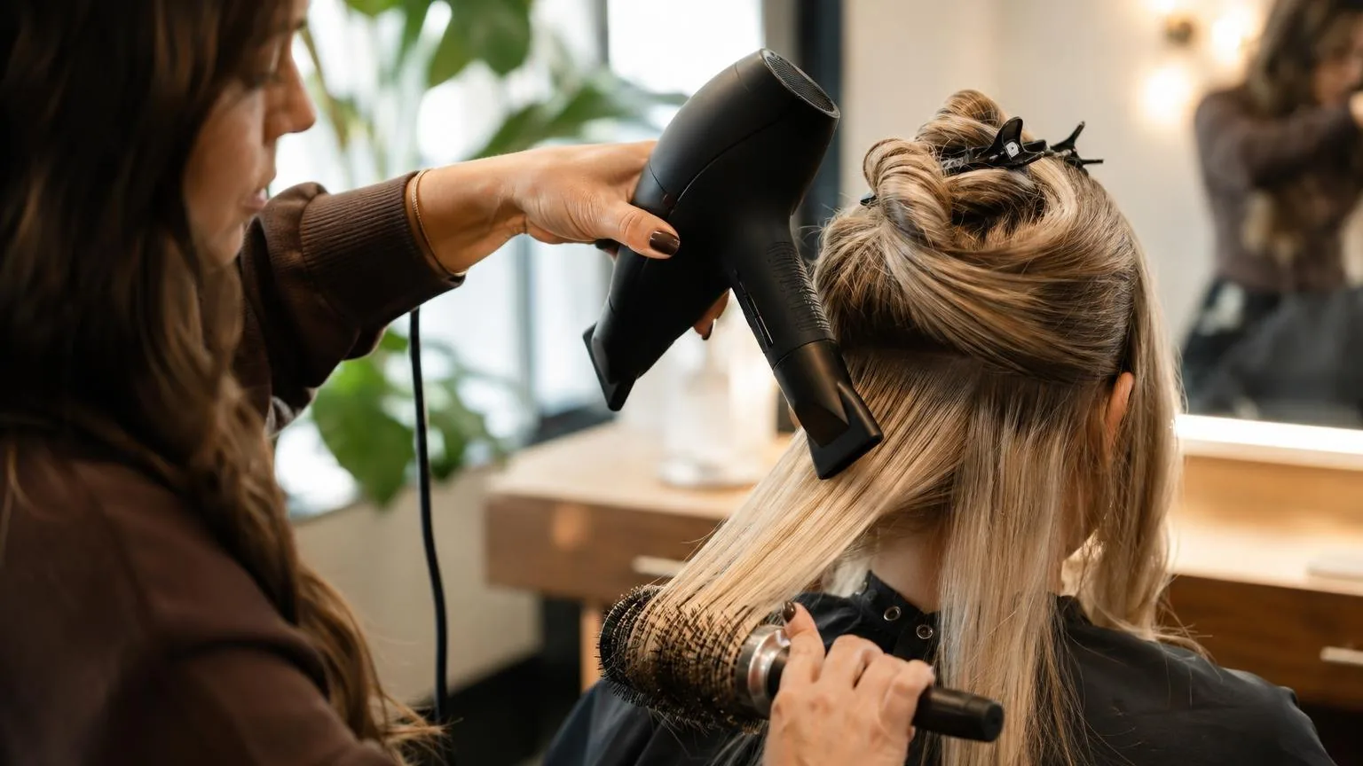 A stylist working through a sectioned blow dry, close-up, in everyday salon practice