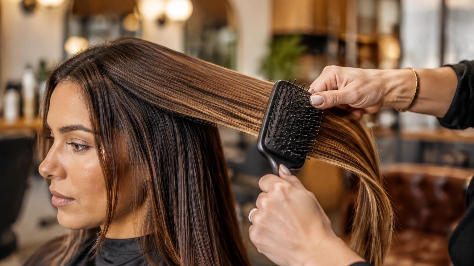 A stylist working through a sectioned blow dry, close-up, during a real blow dry